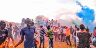 Young people in Loitokitok, Kenya throw pots of brightly-coloured powdered paint as part of the ICS-organised ‘Colourfest’