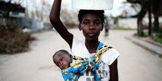 Sister carries brother in Mozambique