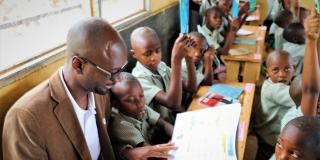Papa Diouf reading to primary school pupils