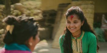 Nirmala smiles as she sits on the floor to talk with 'Big Sister' Durga