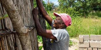 A man works to rebuild a house damaged by Cyclone Idai in 2019