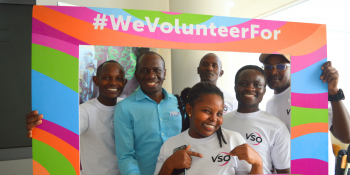 Volunteers pose in a #WeVolunteerFor photo frame