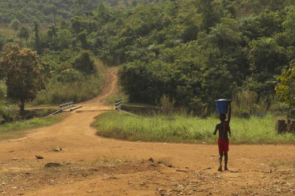 A boy carries water outside the village of Charlotte in Sierra Leone