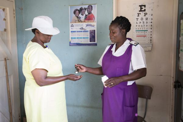 A nurse gives medication to a female inmate in the Chikurubi prison clinic
