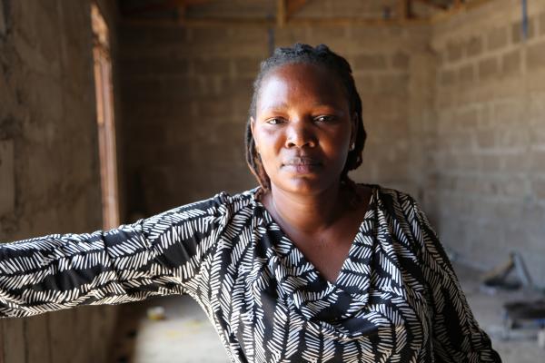Felister Matoke Nyange stands in the staff accommodation she is building for her team of tailors