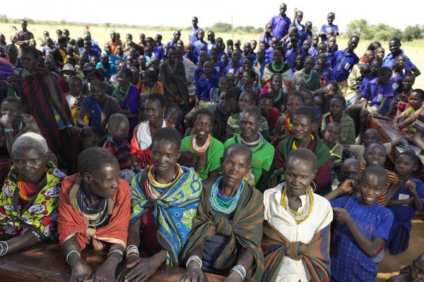 A large group of children and their parents gather outside at Archerer Primary School, waiting for a dance performance to begin