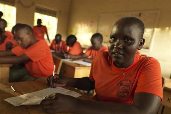 Student Stella works at her desk a the classroom at Kangole Girls' Secondary School, Moroto