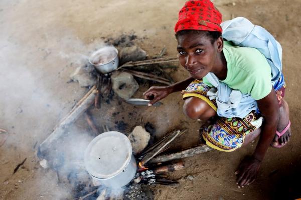 A young lady cooks on a fire in Mozambique