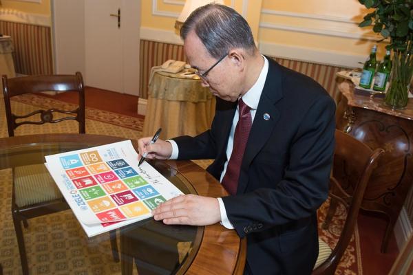 Former UN Secretary-General Ban-Ki Moon signs a poster of the Sustainable Development Goals