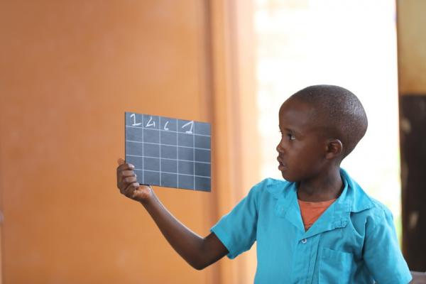 Child holding a chalkboard. Rwanda