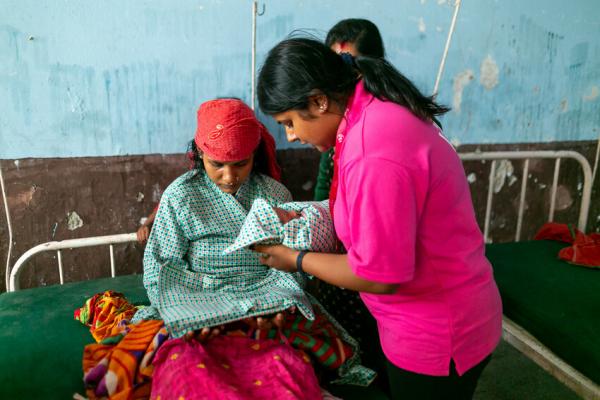 Manisha talks to a new mother in hospital