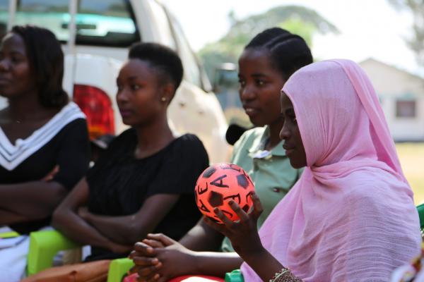 Jida, a young woman, holds a small football as part of a warm-up exercise in an aspirations analysis session