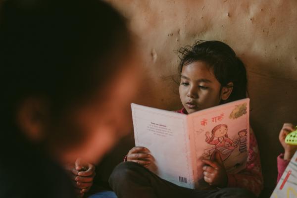 A child reads a book in a community library in Nepal