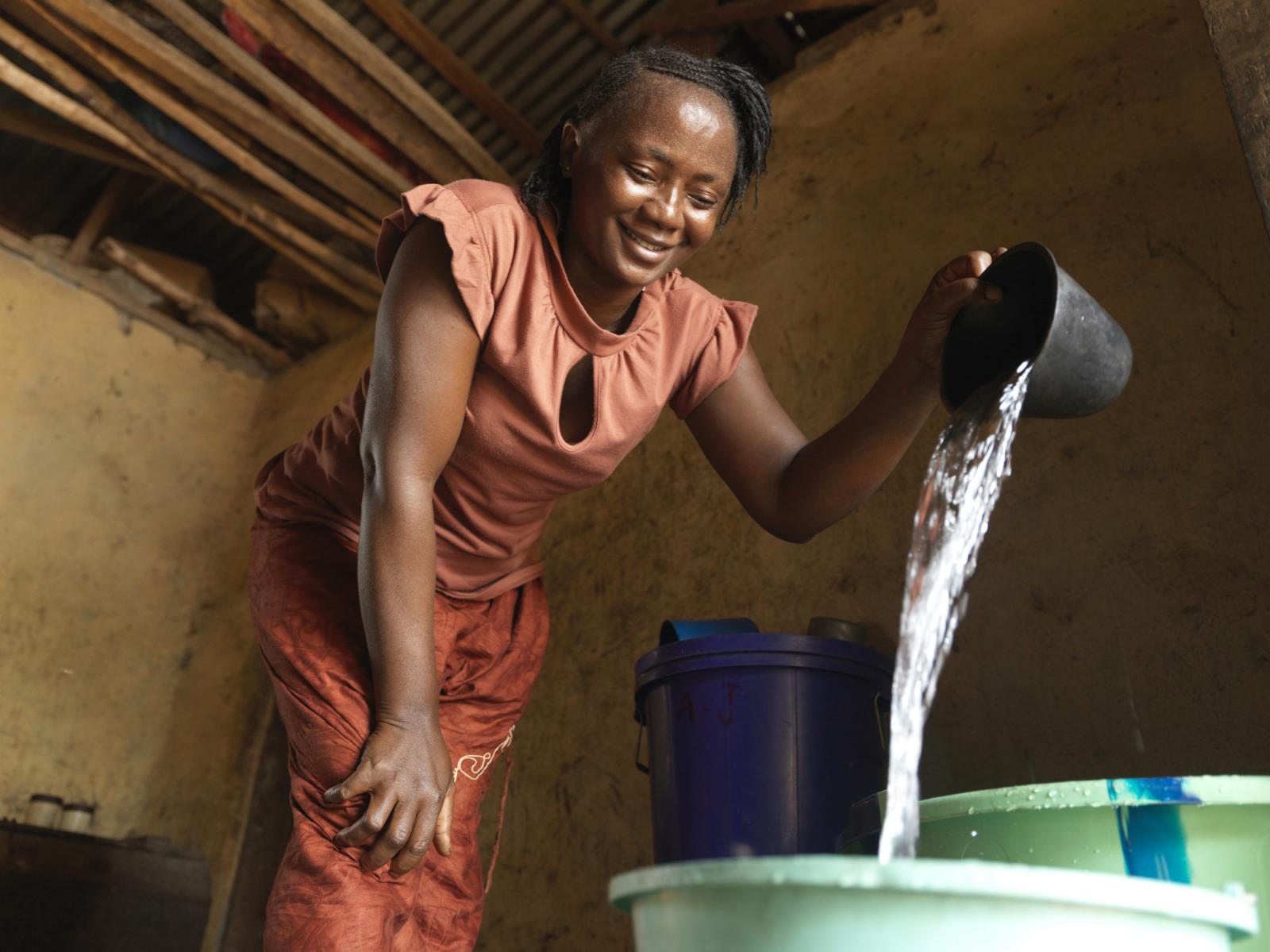 Fatmata Kaloko accesses clean water from her local water pump which was provided by VSO and Wateraid.