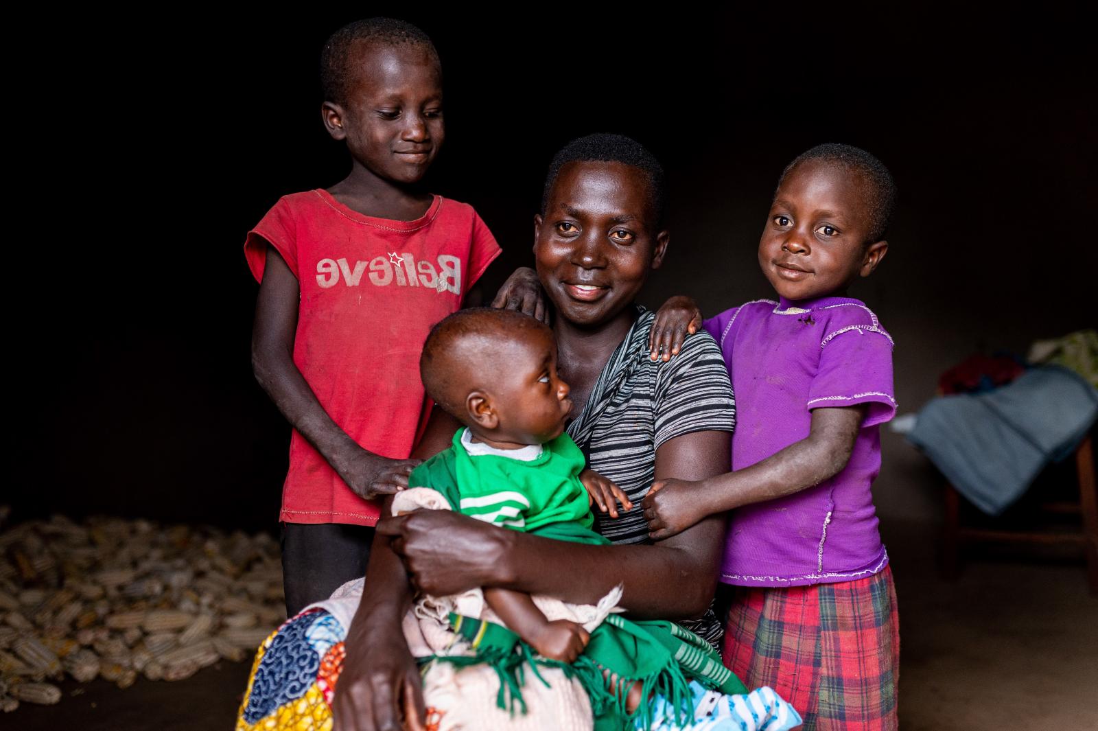 Young woman with two children and a baby on her lap