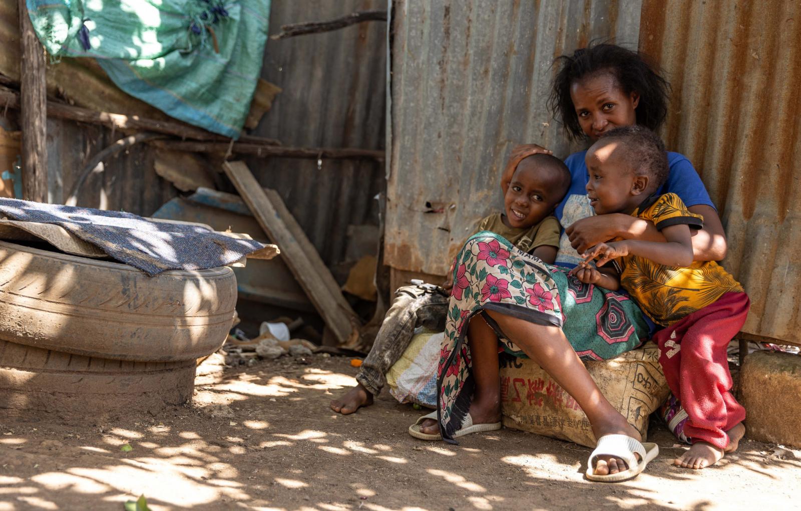 Elizabeth, waste picker, with her two children at her home