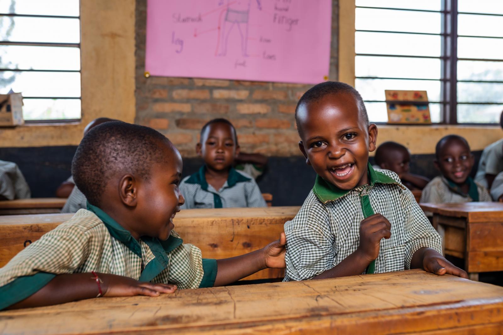 Two primary school children, laughing in class.