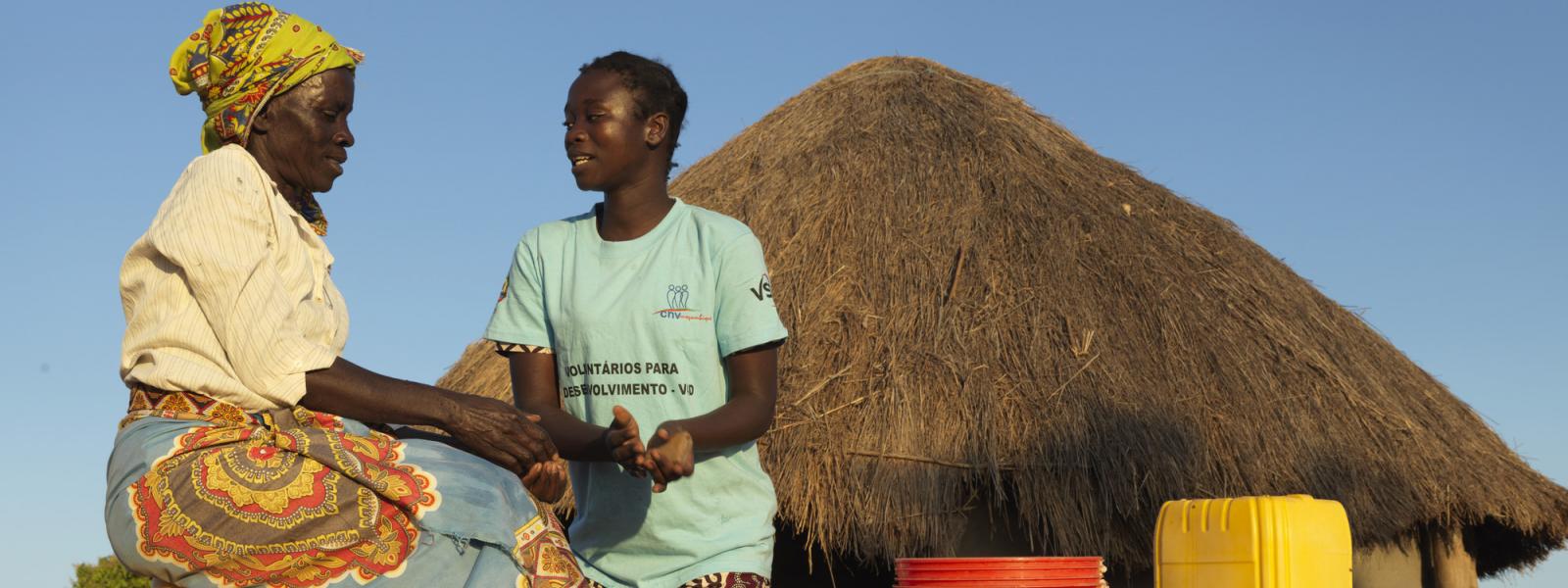 Community volunteer Rosaria teaches local resident Gloria how to wash hands with ash, soap and water in a cholera prevention campaign after cyclone Idai