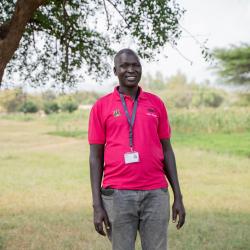 VSO volunteer Alfred, smiling at the camera.