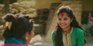 Nirmala smiles as she sits on the floor to talk with 'Big Sister' Durga