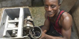 Foday Lansana, local mechanic in Nengbema village, Sierra Leone fixing a water pump.