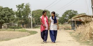20-year-old "Big Sister" Seema walks with her "Little Sister," 15-years-old Pramila, towards Pramila's schoo