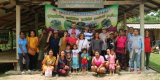 A large group of people pose in front of a community building