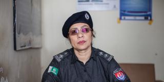 A female police officer sits behind her desk in the police station