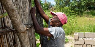 A man works to rebuild a house damaged by Cyclone Idai in 2019