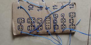 A piece of cardboard with diagrammes and numbers to help pupils learn simple addition