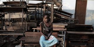 Celia, 12, sits in front of some damaged school tables after Cyclone Idai