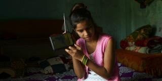 Girl in Nepal listening to radio lessons during COVID-19 lockdown