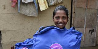 A young girl in Nepal thrilled to receive her hygiene kit from VSO