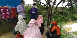 Volunteers wear masks while teaching COVID-19 safety awareness