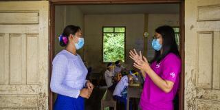 Volunteer and headteacher speak at a school in Mon state, Myanmar