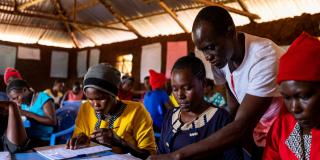 Volunteer Peter helps some pupils at a VSO-supported learning centre