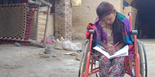 Rabina doing her school work in her wheelchair