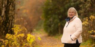 Volunteer Carol Carson walks in woodland in Scotland 