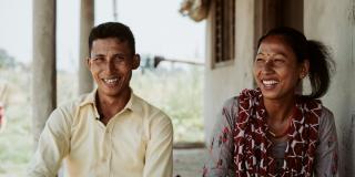 Couple smiling at camera.