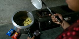 A saucepan containing rice next to a stove.