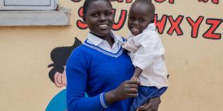 Student Emily stands outside her school with her son, Shedi