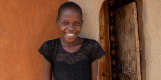 Nakiru smiling, outside her home.