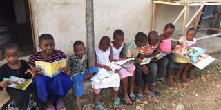 Children reading on a step Children reading on a step in Tanzania