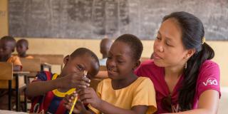 7-year-old Blessing Asokiyine (centre) with her 6-year-old classmate Klevin Atinga and VSO volunteer Mary Carnable, at Goriko kindergarten in Talensi District, Bolgatanga, Ghana.