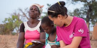 7-year-old Blessing Asokiyine at home with her mother Abodaame (age 46) and VSO volunteer Mary Carnable. Talensi District, Bolgatanga Ghana