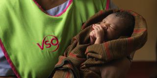 One of the VSO volunteers training nurses and midwives to deliver and care for newborn babies in Uganda A VSO volunteer holding a newborn baby