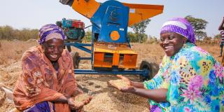 Fatima Zubairu and Fatima Al Hassan are pictured here with a thresher machine that strips the husks and stalks from soya beans.