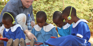 Andrew Ashe with children using tablets to support education in Malawi