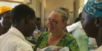 Joanne Awol is congratulated by midwife Gudrun after giving birth to a baby girl.