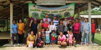 A large group of people pose in front of a community building